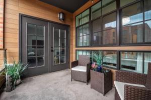 an outdoor patio with chairs and tables and windows at Upscale Condo In Annapolis w/Private Parking in Annapolis