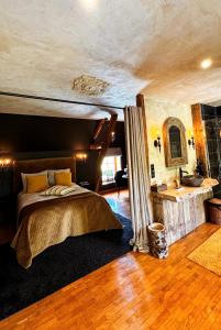 a bedroom with a bed and a bathroom with a sink at La lande sèche in Lainsecq
