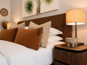 a bedroom with a white bed with pillows and a lamp at One Mile Retreat - Ocean View 3 Bedroom Retreat in Anna Bay