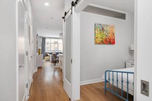 a hallway with white walls and a painting on the wall at Upscale Condo In Annapolis w/Private Parking in Annapolis +21 photos