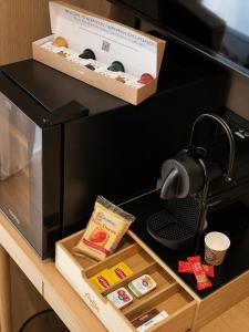 a black microwave with a box on top of it at Residenza Ricci in Azzano San Paolo