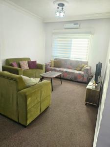 a living room with a couch and a table at الجبيهه شفابدران شقة مفروشة in Amman