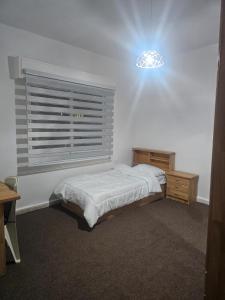 a bedroom with a bed and a window and a light at الجبيهه شفابدران شقة مفروشة in Amman