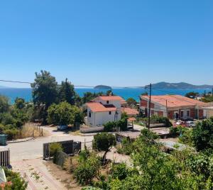 a small town with houses and the ocean in the background at Villa Panthéon in Paleo Tsifliki