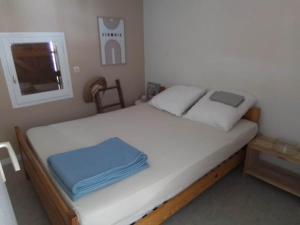 a bedroom with a bed with white sheets and a television at style petit chalet de montagne in Prades