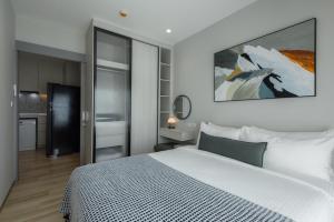 a bedroom with a white bed and a painting on the wall at A417-60m2-2bedroom Serenity 66935B2I976 in Nai Yang Beach