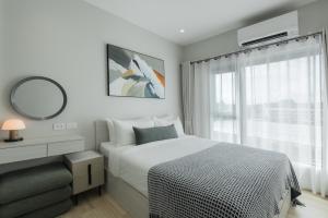 a bedroom with a bed and a mirror and a window at A417-60m2-2bedroom Serenity 66935B2I976 in Nai Yang Beach