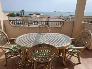 a table and chairs on a balcony with a view at Ático Playa in Cartagena