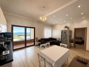 a kitchen and living room with a table and a refrigerator at Guest House Costa 1 in Karianí