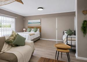 a living room with two beds and a couch at Nine on Uys street B & B in Jeffreys Bay