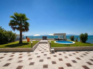 a resort with a palm tree and a swimming pool at Guest House Costa 1 in Karianí