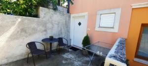 a patio with two chairs and a table and a door at Apartment Carolina - Hillside Stay, Steps from the Sea in Portorož