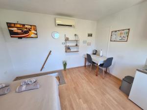 a room with a bed and a desk and a table at Apartment Carolina - Hillside Stay, Steps from the Sea in Portorož