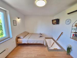 a small bedroom with a bed and a window at Apartment Carolina - Hillside Stay, Steps from the Sea in Portorož