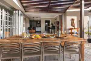 a kitchen and dining room with a table and chairs at Nine on Uys street B & B in Jeffreys Bay