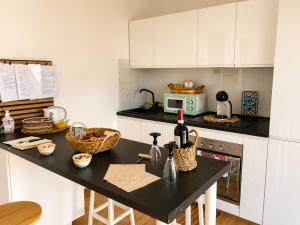 a kitchen with a black counter top and white cabinets at La Dimora di Deborah Terrazza Panoramica, Centro & Stazione a 4 min, Relax e Comfort in Montecatini Terme