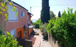 an alley leading up to a house with bushes at Apartment Carolina - Hillside Stay, Steps from the Sea in Portorož