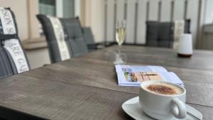 a cup of coffee on a table with a glass of wine at Villa Sonneck, App 07 - Bade- & Saunawelt täglich inklusive in Ostseebad Sellin