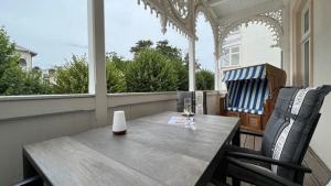 a porch with a wooden table and two chairs at Villa Sonneck, App 07 - Bade- & Saunawelt täglich inklusive in Ostseebad Sellin