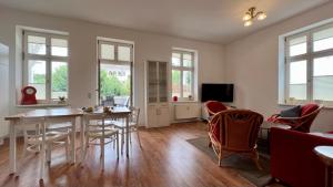a living room with a table and chairs at Villa Sonneck, App 07 - Bade- & Saunawelt täglich inklusive in Ostseebad Sellin