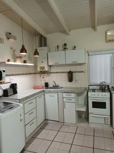 a kitchen with white cabinets and white appliances at Monoambiente Osvaldo in Neuquén