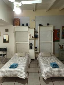 two beds sitting in a room with shelves at Monoambiente Osvaldo in Neuquén