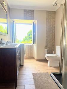 a bathroom with a sink and a toilet and a window at Casa Rua in Lira