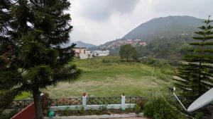 a view of a hill with a town in the distance at Kumaon Breeze homestay in Bhowāli