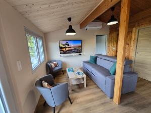 a living room with a couch and two chairs at Les Reflets Verts - Lac de Vouglans in Maisod