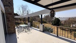 a patio with a table and chairs on a balcony at Nest On Thula in Dullstroom