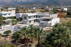 an aerial view of a white house with palm trees at Amara Cove Adults Only by Estia in Malia +63 photos