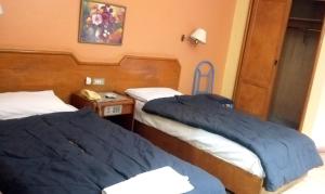 two beds in a hotel room with blue sheets at New Radwan Hotel, Luxor railways in Luxor