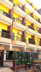 a building with balconies and tables in front of it at New Radwan Hotel, Luxor railways in Luxor