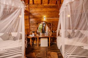 two beds in a room with a table and a mirror at Dudley Nature Resort in Habarana