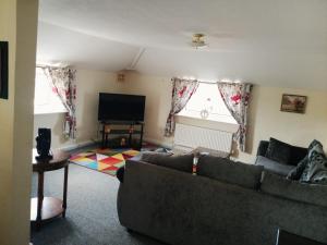 a living room with a couch and a flat screen tv at Fox and Hounds Apartment in Willingham