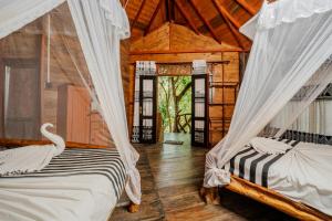 two beds in a room with a swan in it at Dudley Nature Resort in Habarana