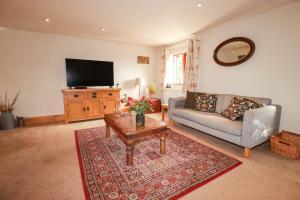 a living room with a couch and a tv at Skylark in Liskeard
