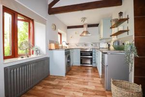a kitchen with white walls and wooden floors and a sink at Skylark in Liskeard
