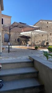 a group of benches and umbrellas in a courtyard at Palazzo Menghina in Casaletto Spartano