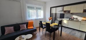 a living room with a couch and a table and a kitchen at Malo misto in Kovačić