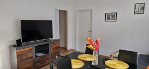a living room with a television and a table with chairs at Malo misto in Kovačić