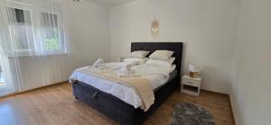 a bedroom with a bed with white sheets and pillows at Malo misto in Kovačić
