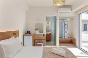 a bedroom with a bed and a bathroom with a sink at Amara Cove Adults Only by Estia in Malia