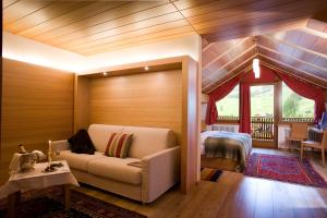 a living room with a couch and a bedroom at Hotel La Villa in La Villa