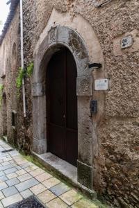 an entrance to a stone building with a brown door at Palazzo Menghina in Casaletto Spartano +12 photos