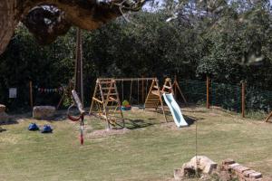a woman playing on a swing set in a park at Agriturismo La Palazzetta di Assisi in Assisi