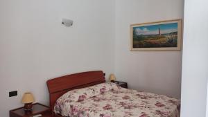 a bedroom with a bed and a picture on the wall at Rose Apartment in Crotone