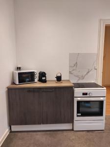 a kitchen with a stove and a microwave at Le first République, gare centre ville in Bourgoin