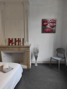 a bedroom with a bed and a chair and a painting at Le first République, gare centre ville in Bourgoin +8 photos