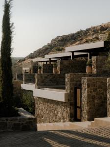 a stone building with potted plants on it at Tropicana Suites & Villas Mykonos in Paradise Beach